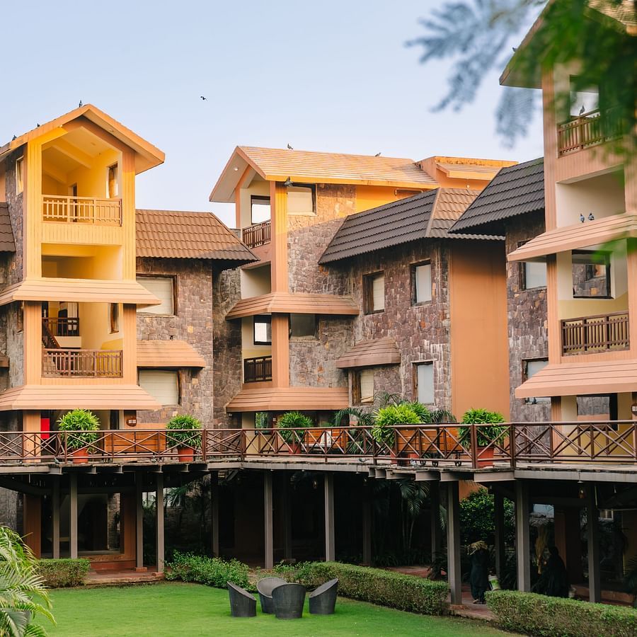 Facade of The Baagh Ananta Elite, Ranthambore, with a front lawn area featuring a coffee table and chairs